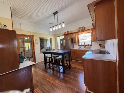 a kitchen with stainless steel appliances wooden floor dining table and chairs