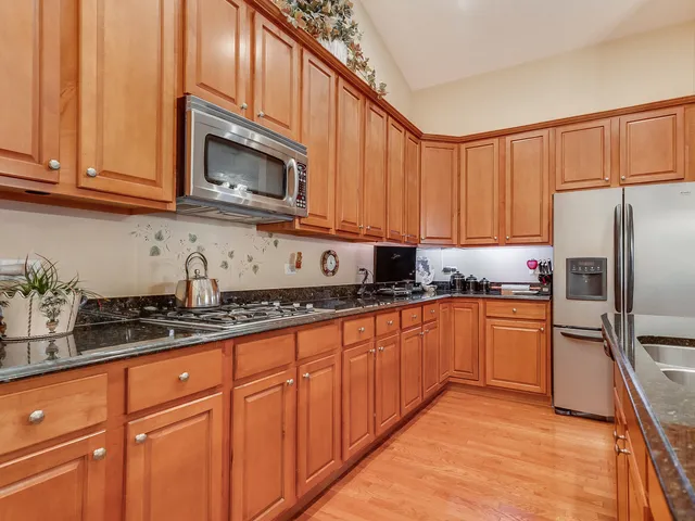 a kitchen with granite countertop stainless steel appliances a sink microwave and stove