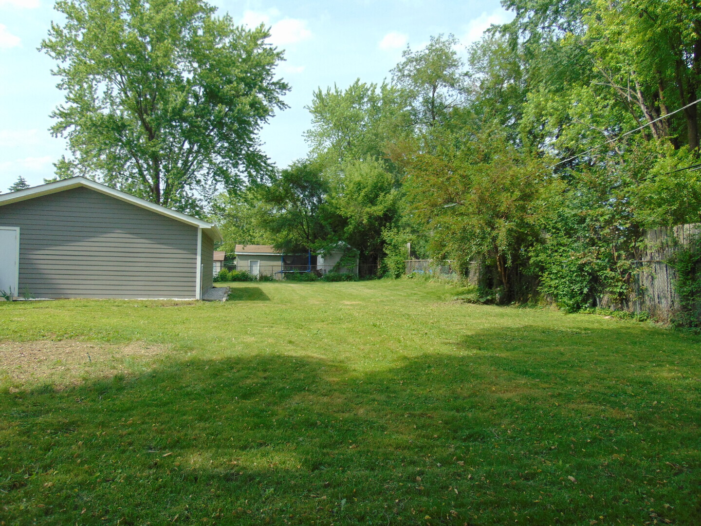 6310 Hilly Way Cary, IL 60013 - Photo 58 of 67 a backyard of a house with plants and large tree