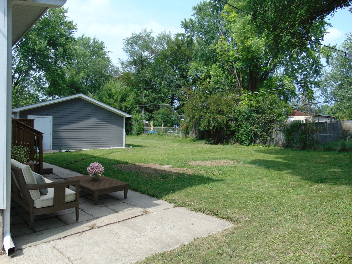 6310 Hilly Way Cary, IL 60013 - Photo 62 of 67 a view of a backyard with table and chairs with a barbeque grill and plants