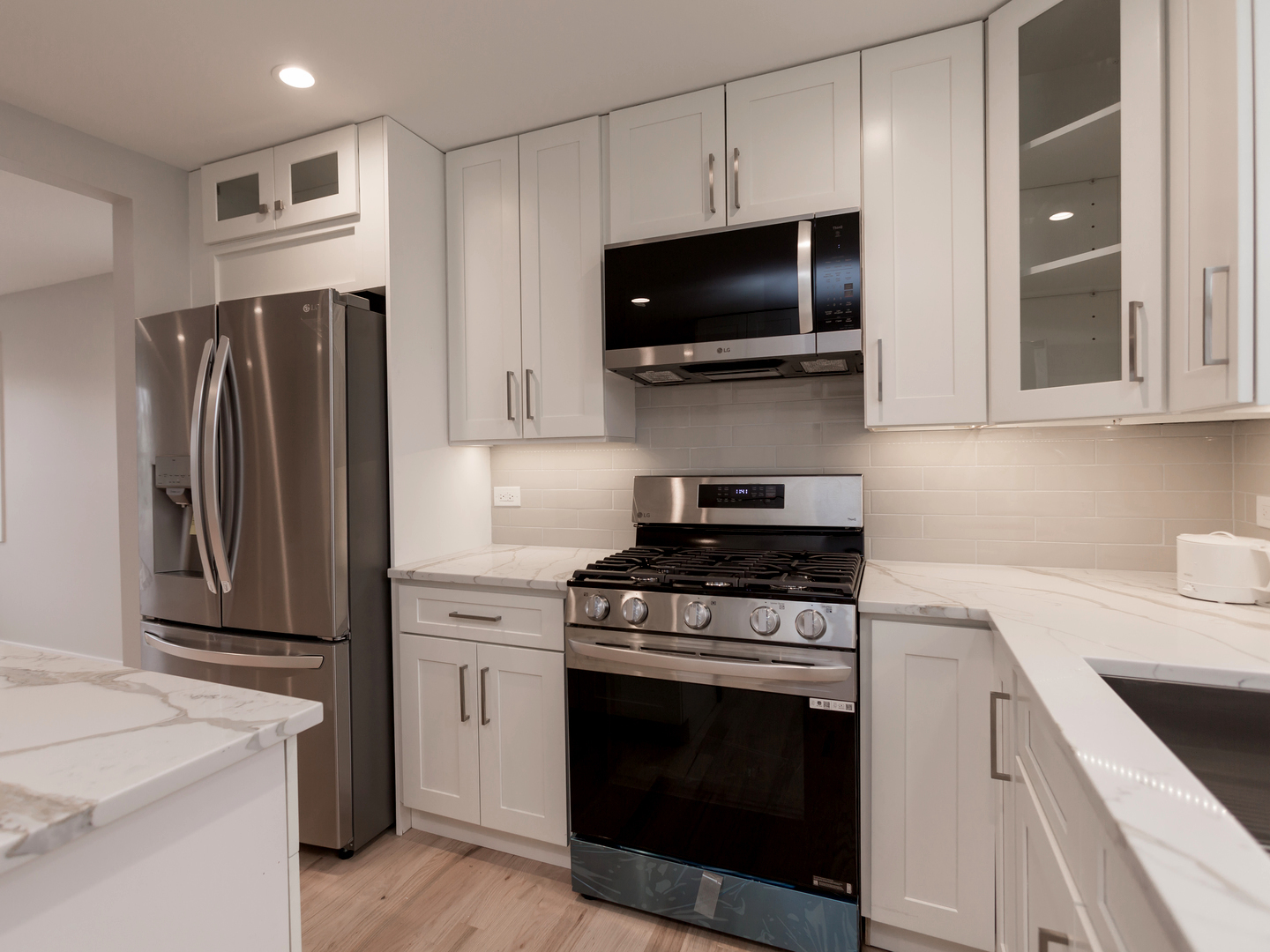 6310 Hilly Way Cary, IL 60013 - Photo 7 of 67 a kitchen with stainless steel appliances a stove a microwave and white cabinets