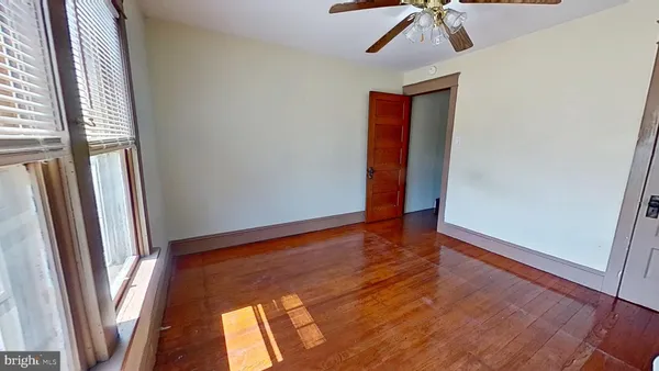 a view of hallway with window and wooden floor
