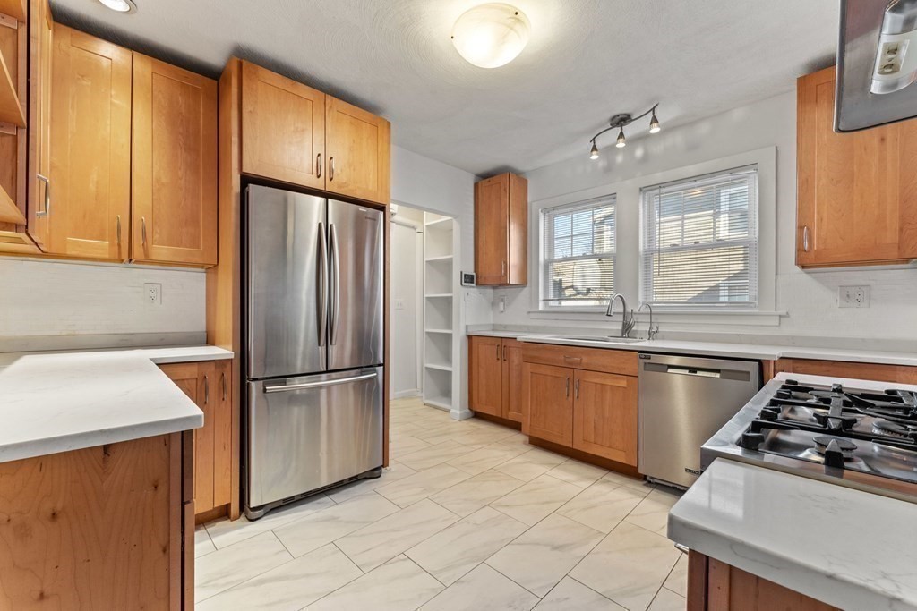 54 Chester Road, Unit 1 Belmont, MA 02478 - Photo 16 of 31 a kitchen with granite countertop a sink stainless steel appliances and cabinets