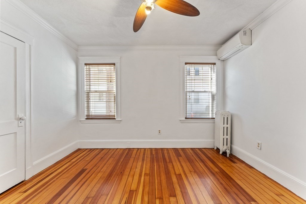 54 Chester Road, Unit 1 Belmont, MA 02478 - Photo 22 of 31 an empty room with wooden floor and windows
