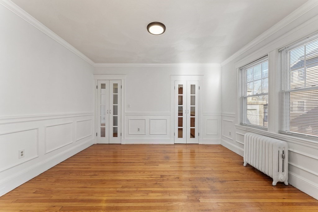 54 Chester Road, Unit 1 Belmont, MA 02478 - Photo 9 of 31 a view of an empty room with wooden floor and a window