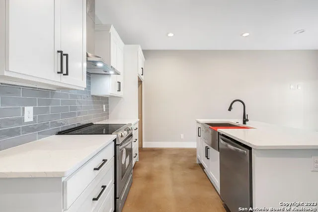 a kitchen with a sink a stove and cabinets
