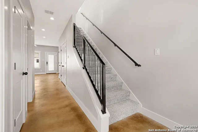 a view of a hallway with wooden floor and staircase