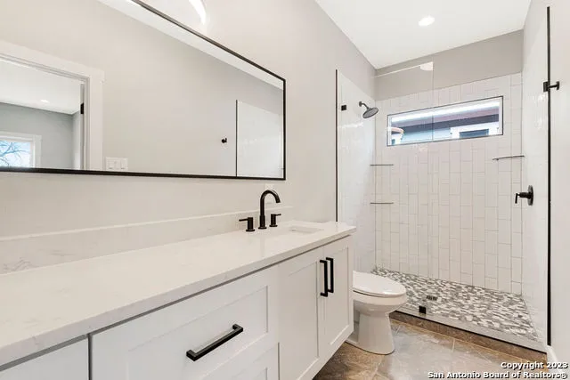 a bathroom with a sink a toilet and shower