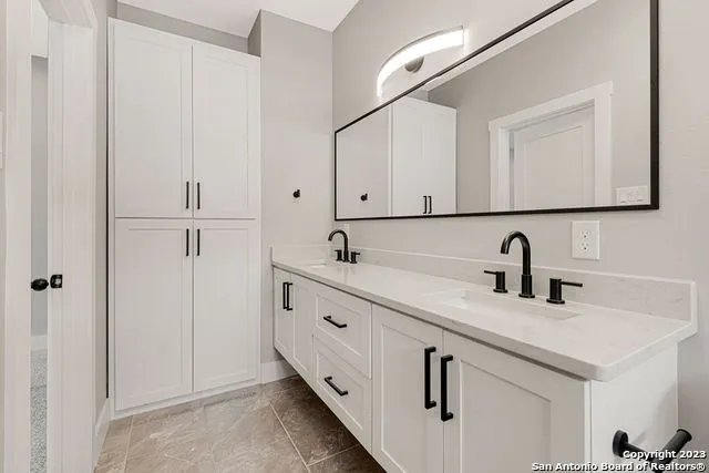 a bathroom with double sink and a mirror