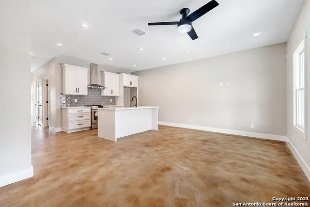 a view of a kitchen with a sink and dishwasher a refrigerator with wooden floor