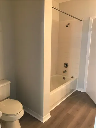 a white toilet sitting next to a bath tub