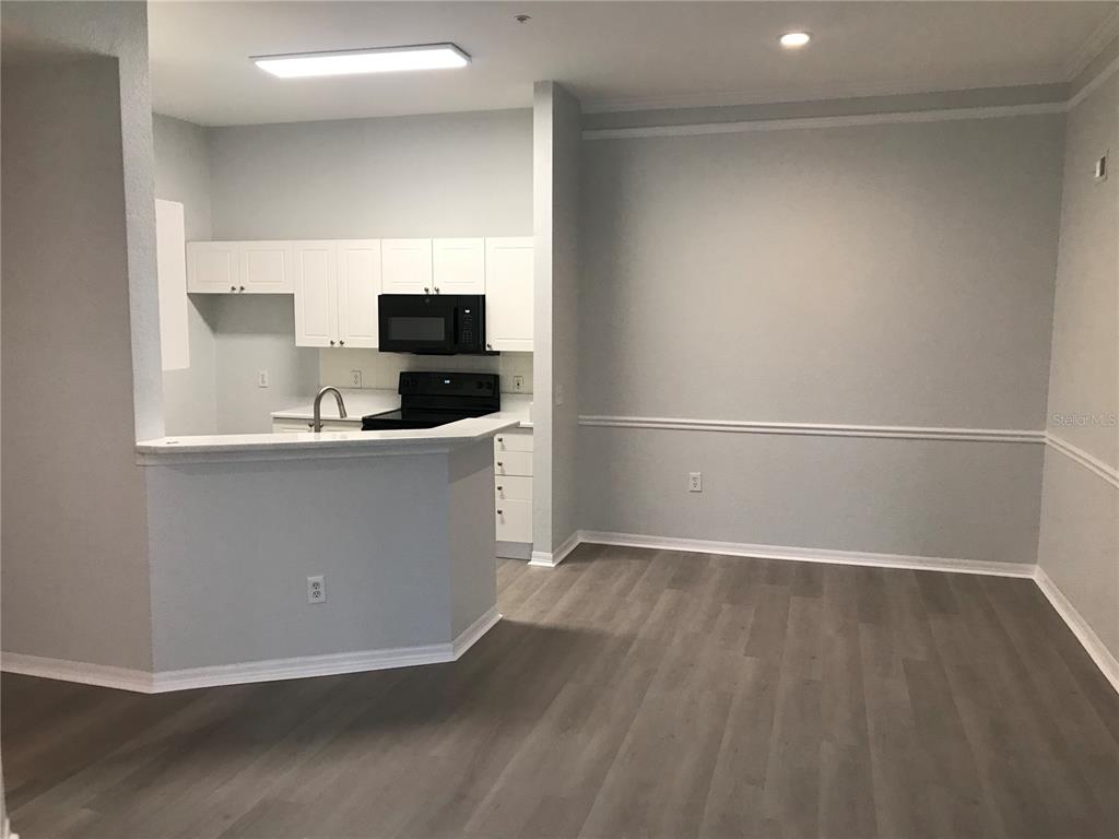 5122 Northridge Road, Unit 306 Sarasota, FL 34238 - Photo 5 of 21 a view of a kitchen with wooden floor and electronic appliances