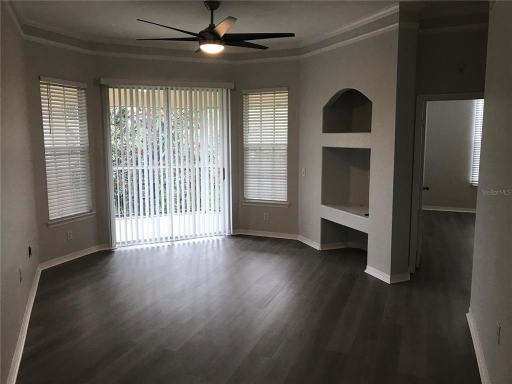 5122 Northridge Road, Unit 306 Sarasota, FL 34238 - Photo 6 of 21 an empty room with wooden floor fan and windows