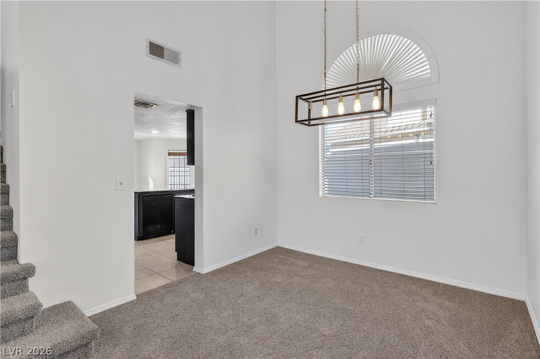 3156 Terrace View Drive Laughlin, NV 89029 - Photo 11 of 94 A striking linear chandelier illuminates this spacious dining area with soaring ceilings and soft carpeting.