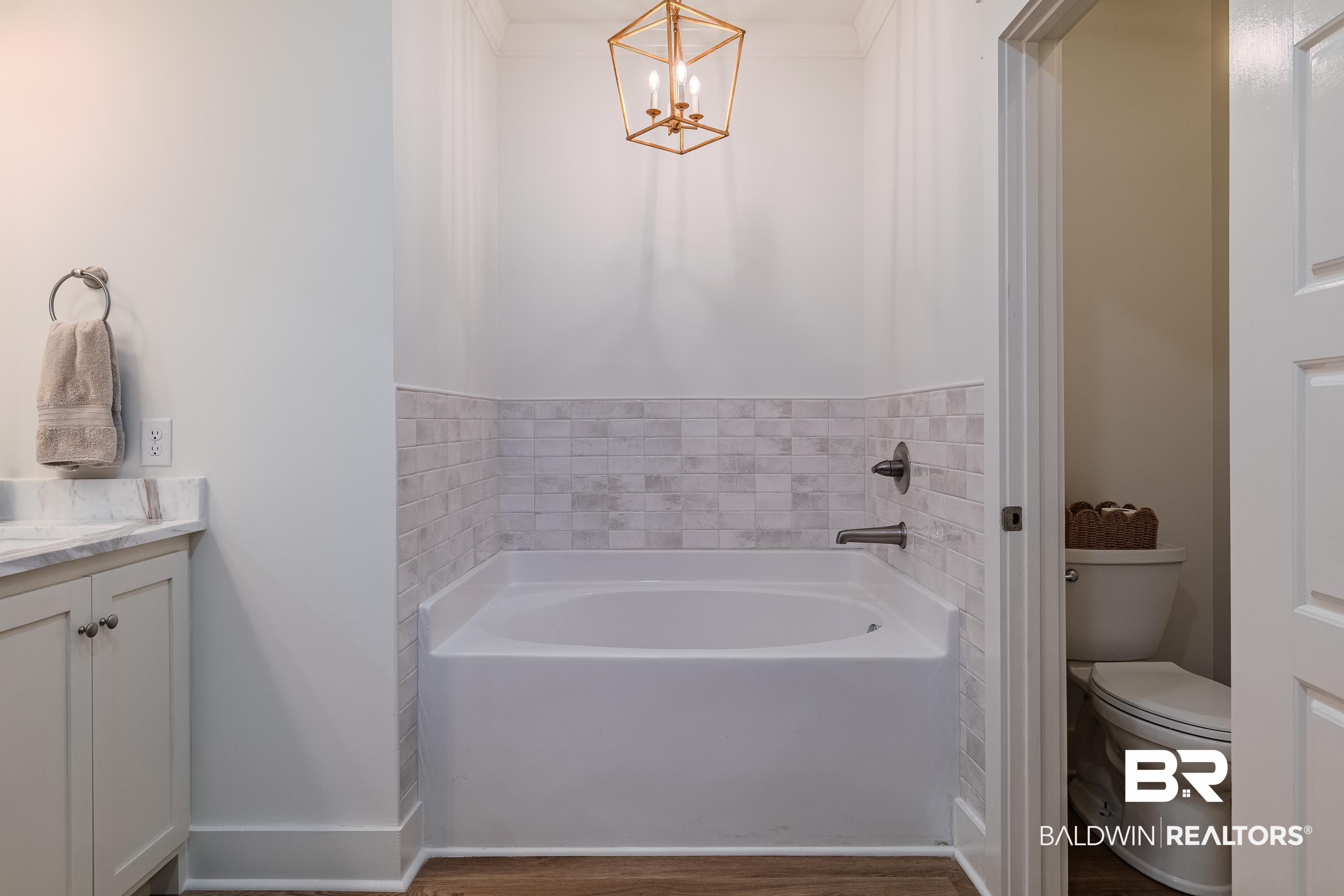 19121 Boothe Road Fairhope, AL 36532 - Photo 19 of 41 Full bath with vanity, a garden tub, dark wood-type flooring, and hanging lights