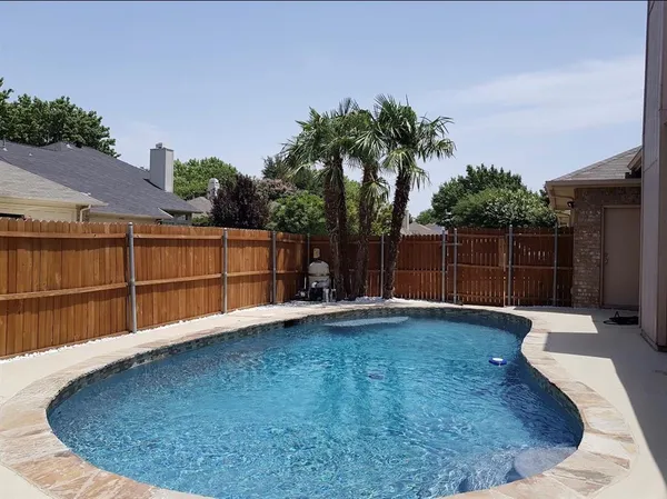 a view of a backyard with wooden fence