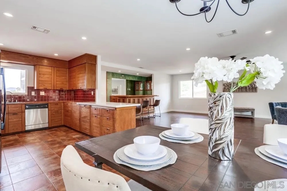 1839 Kent Place Vista, CA 92084 - Photo 20 of 40 a kitchen with stainless steel appliances kitchen island granite countertop a table and chairs in it
