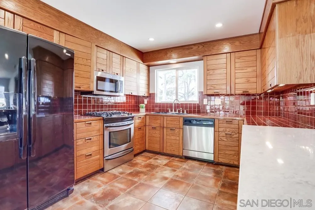 1839 Kent Place Vista, CA 92084 - Photo 21 of 40 a kitchen with stainless steel appliances granite countertop a stove a sink and a refrigerator