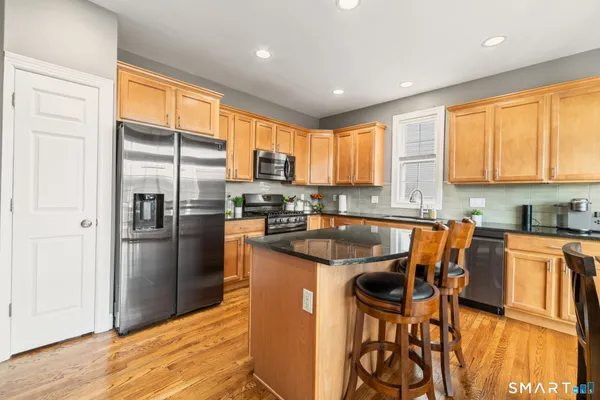 a kitchen with stainless steel appliances granite countertop a refrigerator and a stove top oven
