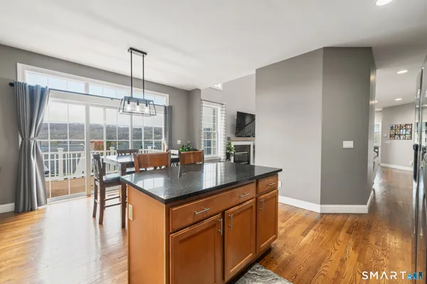 a kitchen with kitchen island granite countertop a sink stove and wooden floor