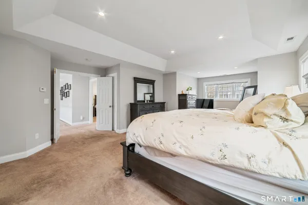 a large bed sitting in a spacious bedroom next to a window