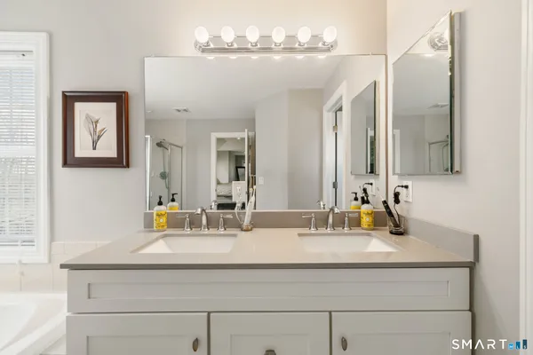 a bathroom with double vanity sinks a vanity and a mirror