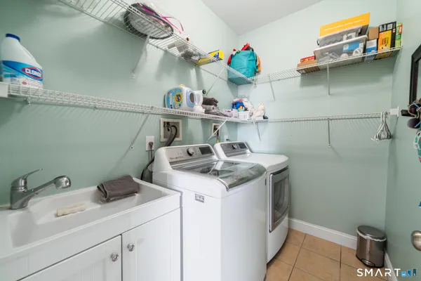 a utility room with a sink a stove and cabinets