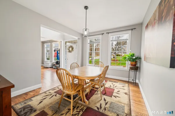 a dining room with furniture a chandelier and wooden floor