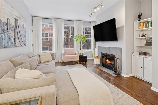 a living room with furniture a flat screen tv and a fireplace