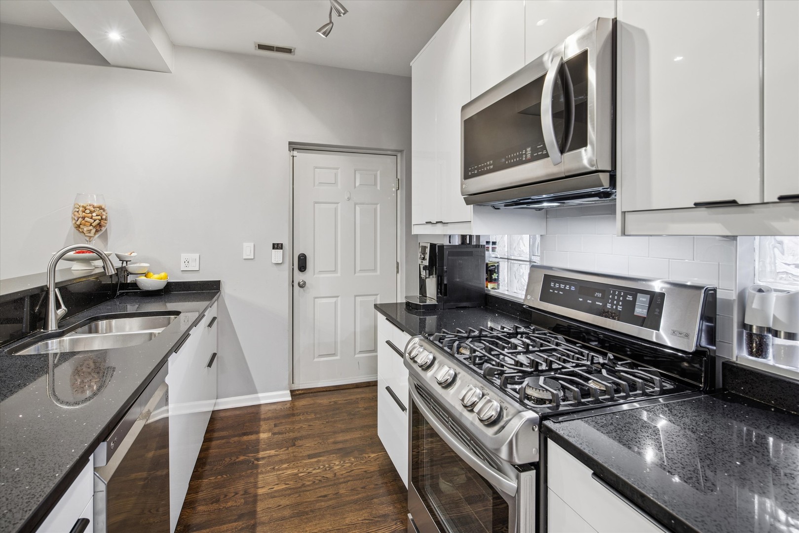 301 West Scott Street, Unit 103 Chicago, IL 60610 - Photo 7 of 17 a kitchen with stainless steel appliances granite countertop a sink stove and cabinets
