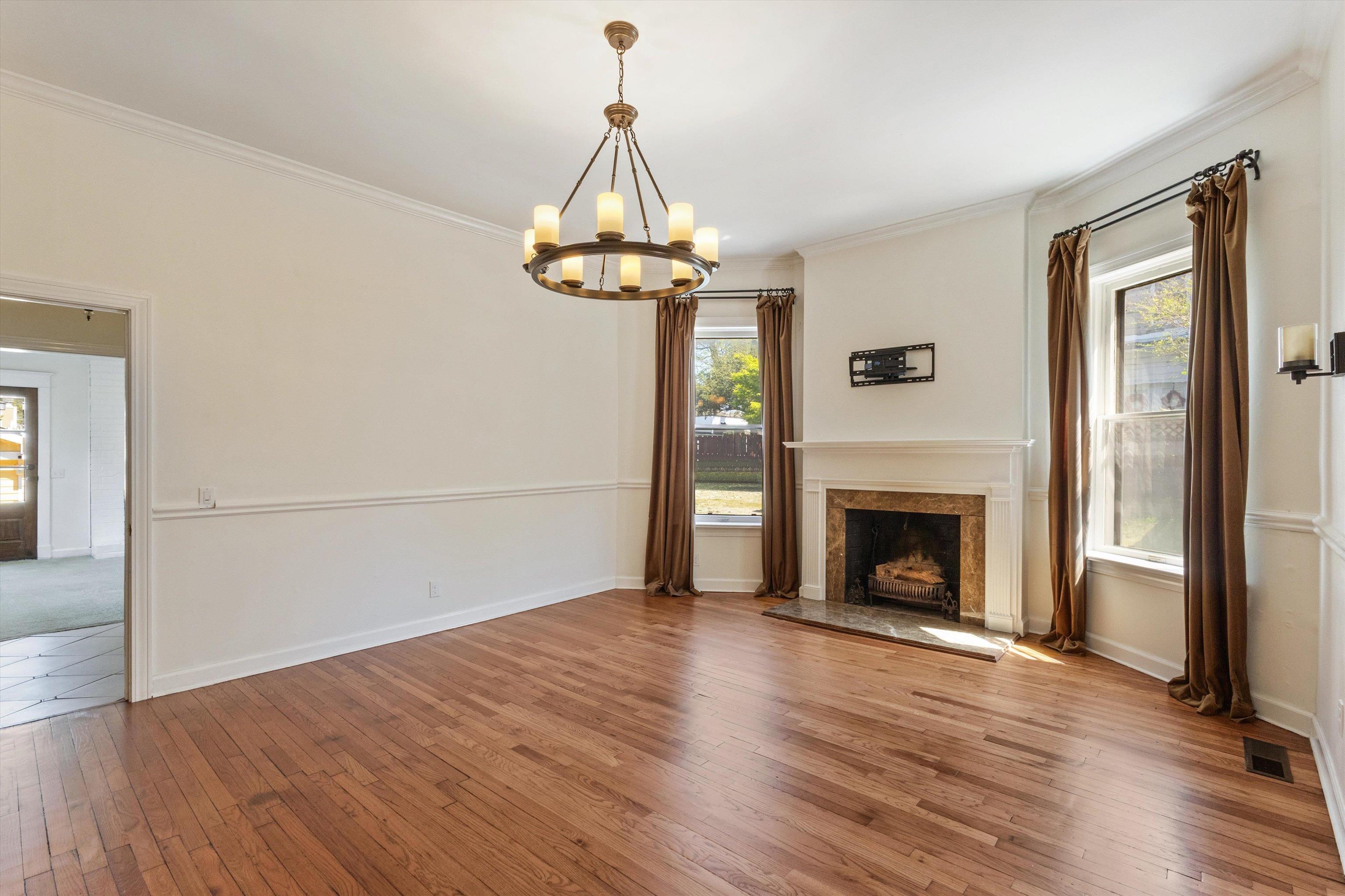 1680 Carruthers Place Memphis, TN 38112 - Photo 13 of 39 a view of empty room with wooden floor fireplace and a window