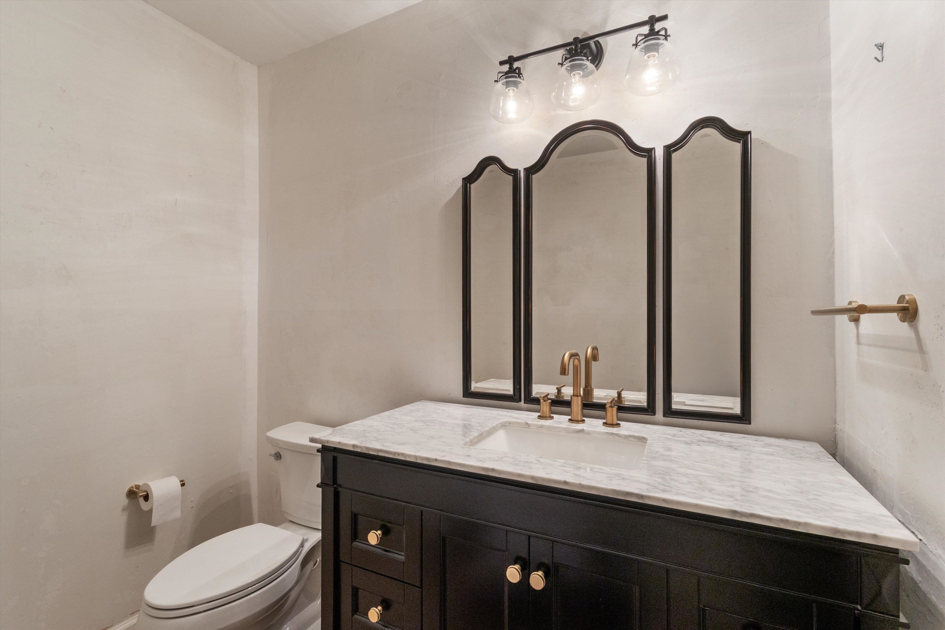 1680 Carruthers Place Memphis, TN 38112 - Photo 16 of 39 a bathroom with a granite countertop sink vanity mirror and toilet