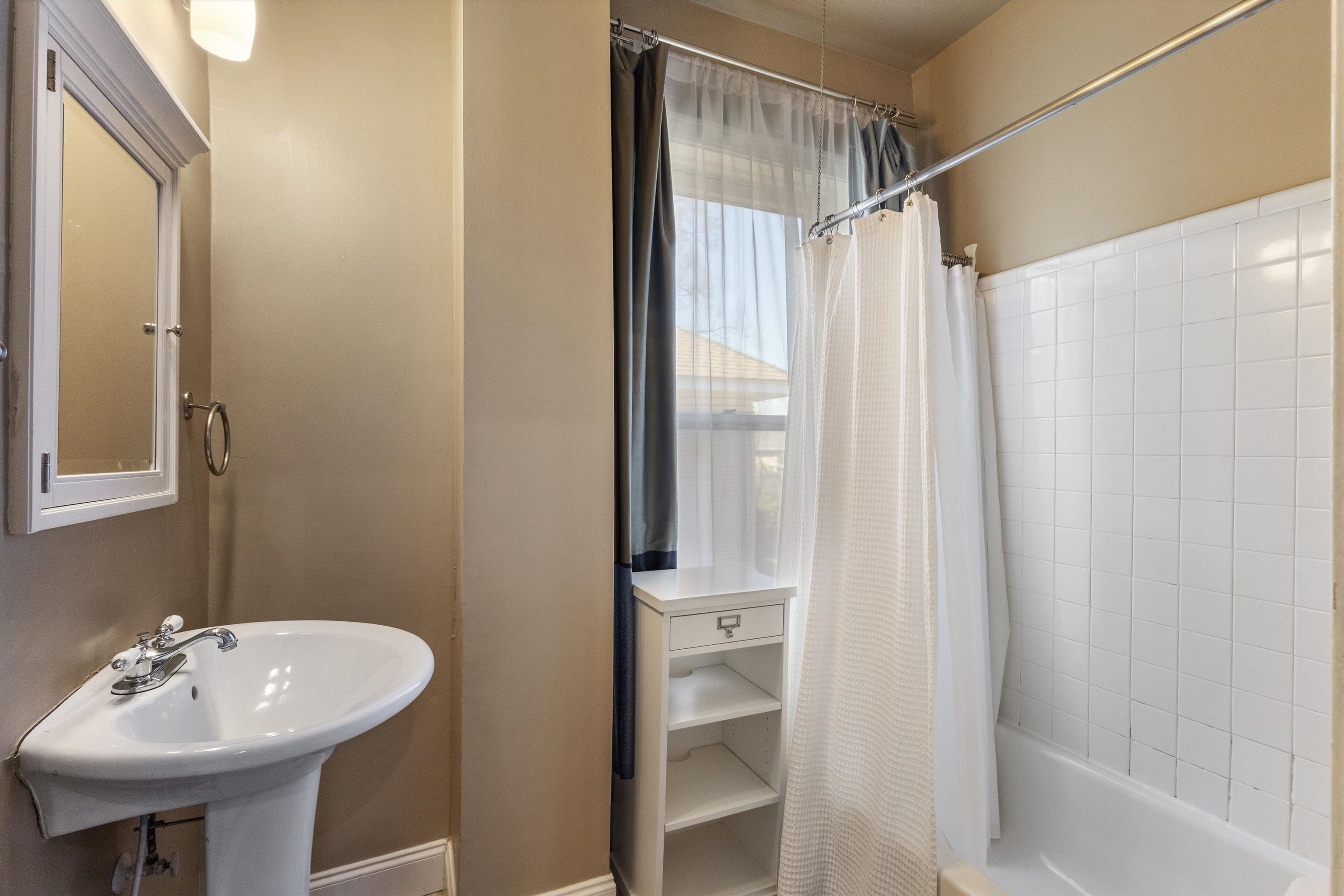 1680 Carruthers Place Memphis, TN 38112 - Photo 25 of 39 a bathroom with a sink a mirror and a shower