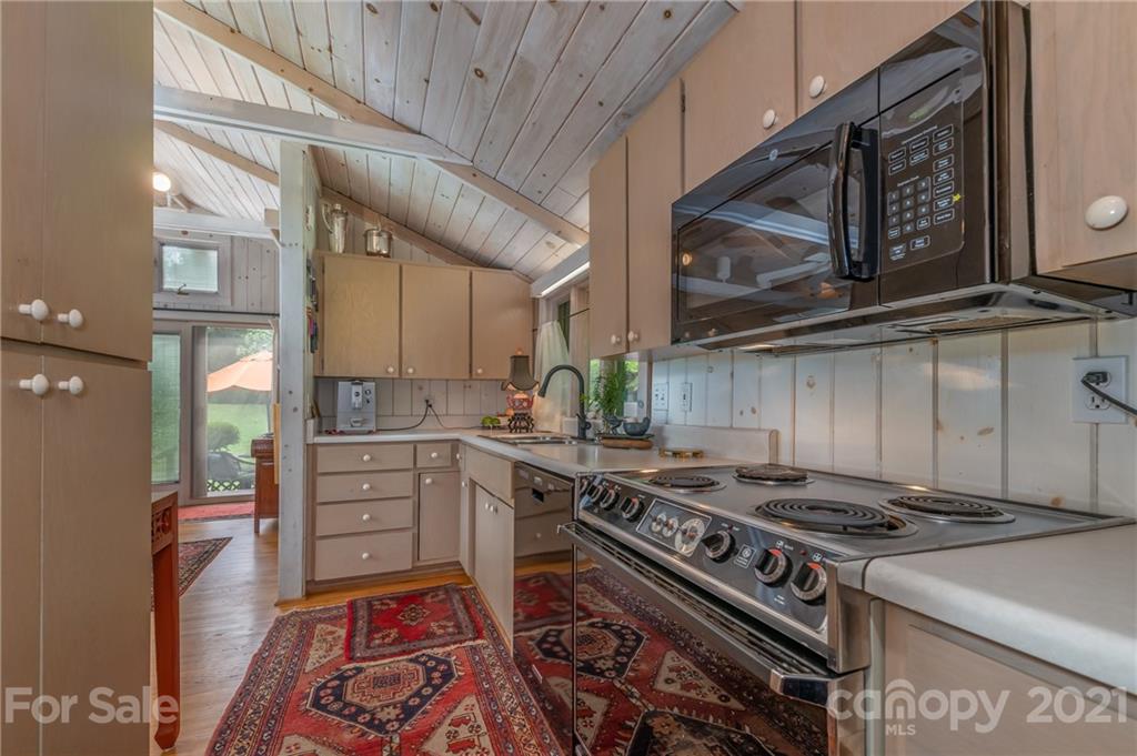 133 Ridgetop Road, Unit 16 Tryon, NC 28782 - Photo 14 of 23 a kitchen with stainless steel appliances granite countertop a stove and a microwave