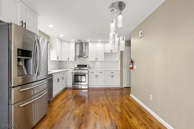 a kitchen with stainless steel appliances a refrigerator and a stove top oven