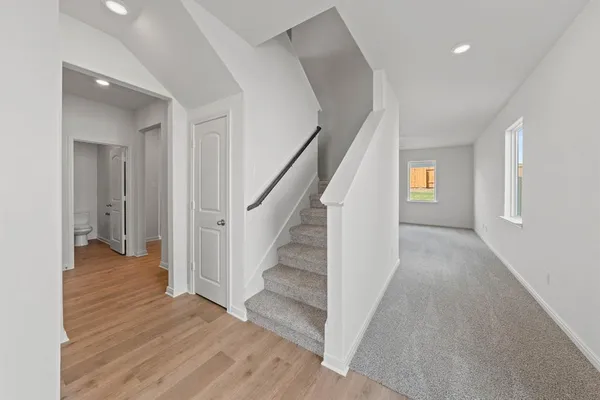 a view of a hallway with wooden floor and staircase