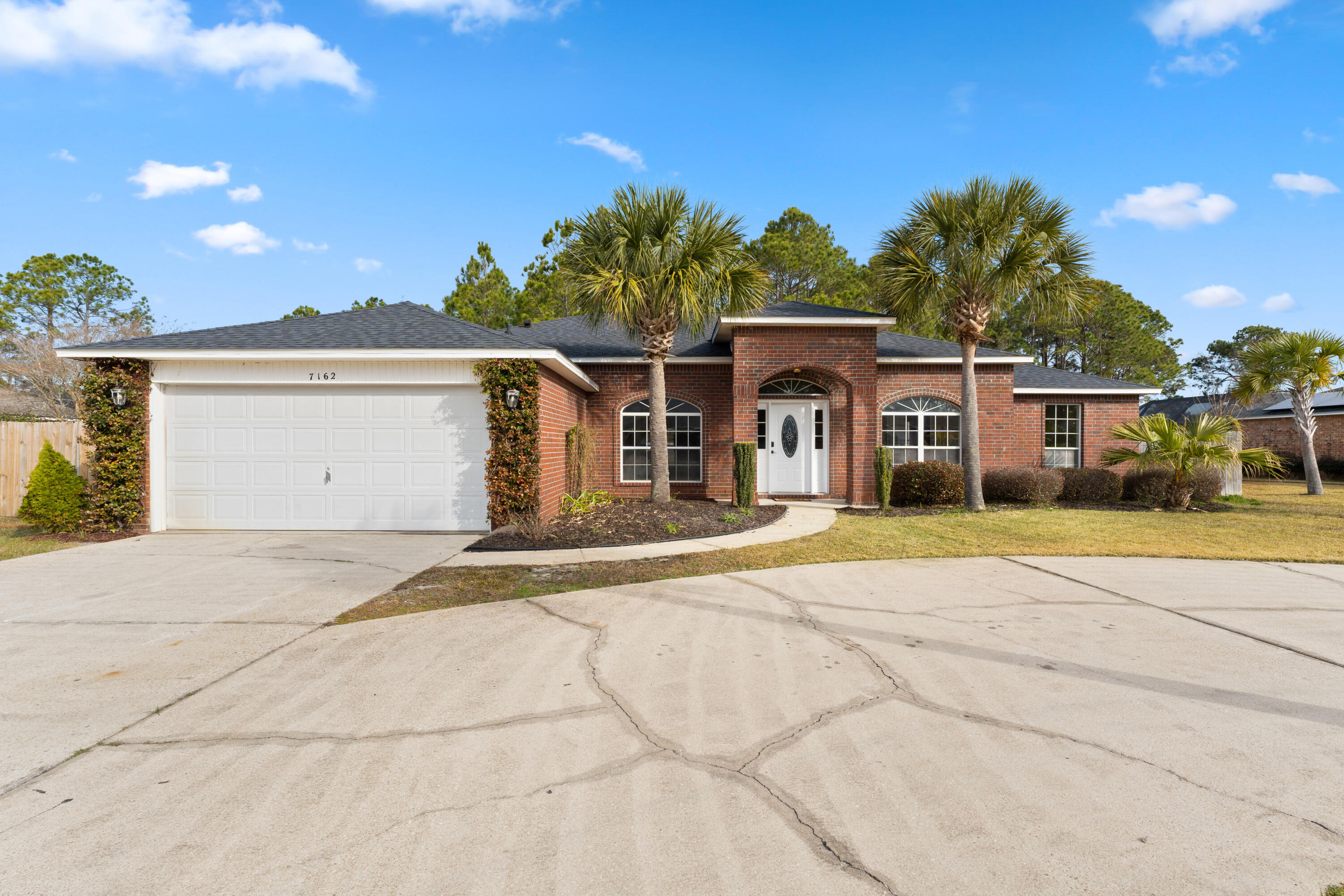 7162 Riverview Road Navarre, FL 32566 - Photo 1 of 33 a front view of a house with a yard and garage