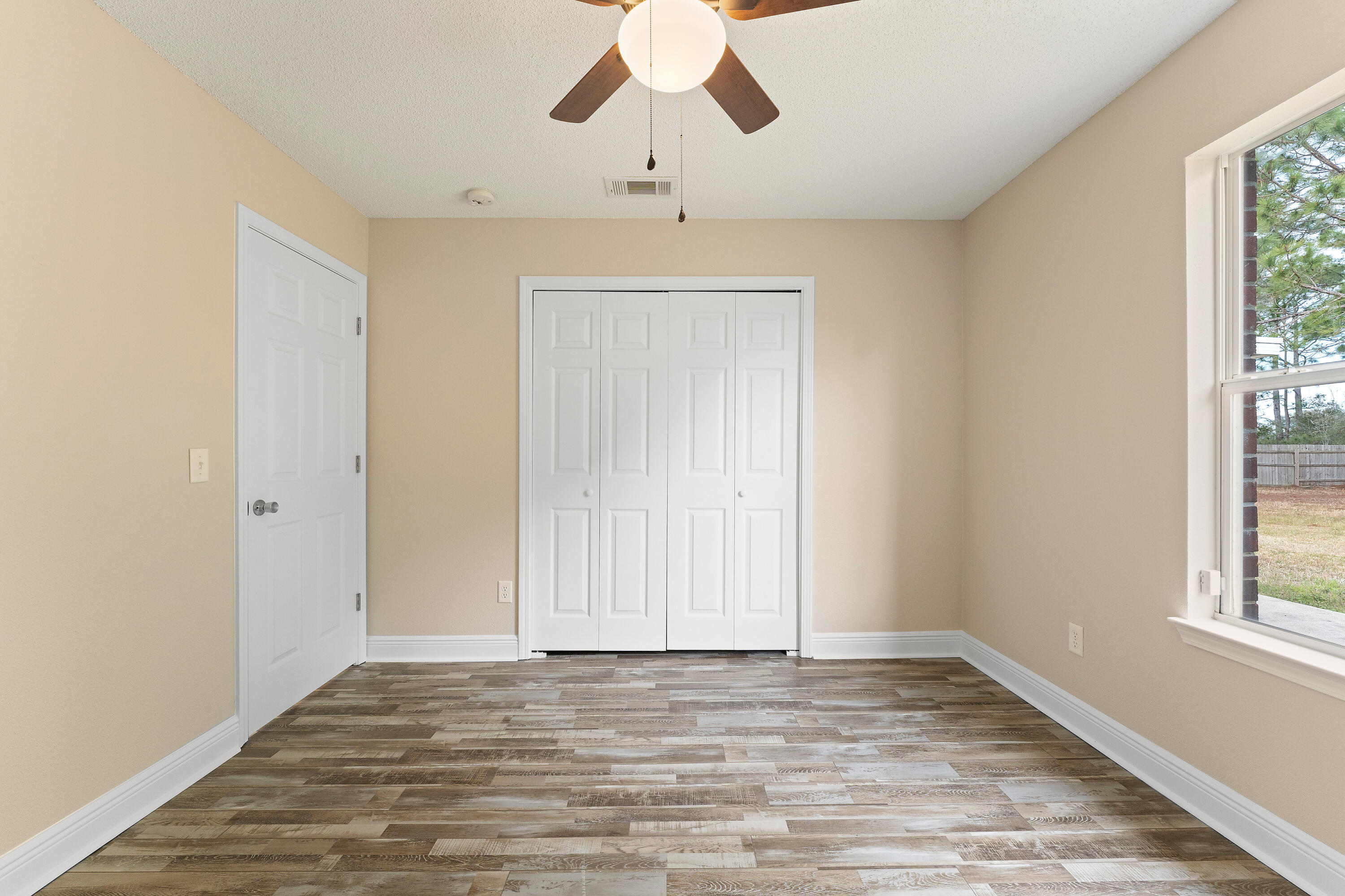 7162 Riverview Road Navarre, FL 32566 - Photo 17 of 33 wooden floor in an empty room with a window