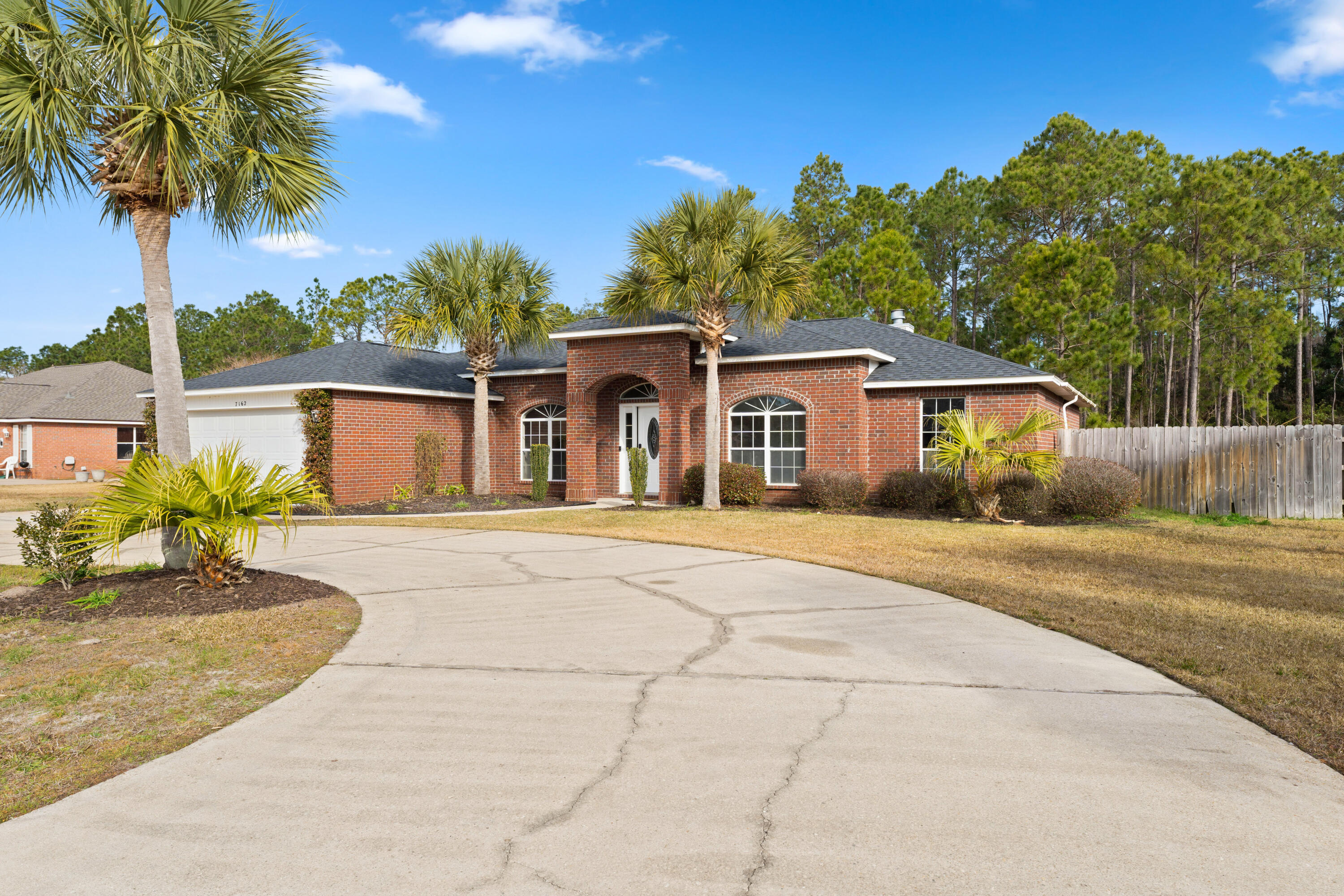 7162 Riverview Road Navarre, FL 32566 - Photo 3 of 33 a front view of a house with a yard and potted plants