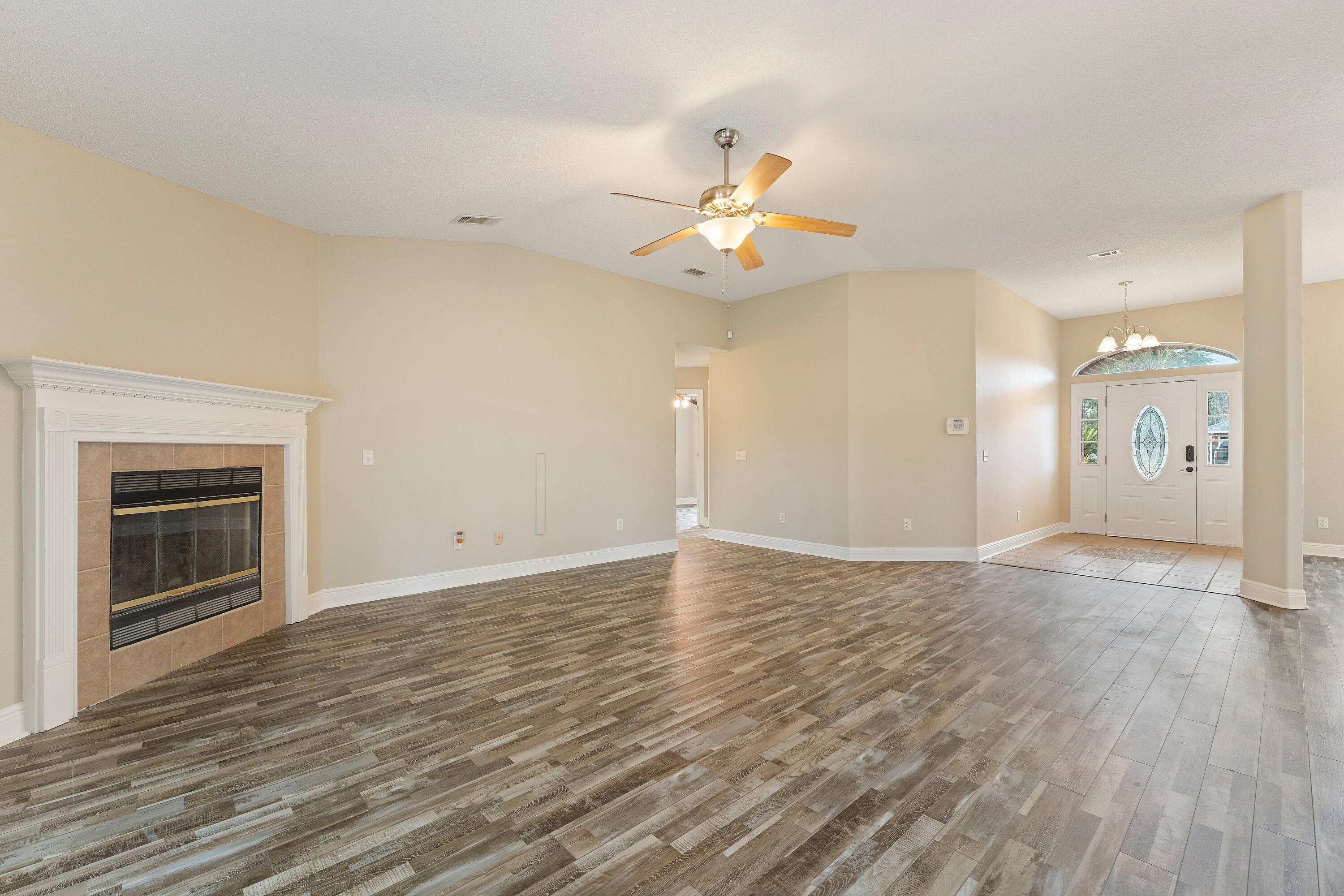 7162 Riverview Road Navarre, FL 32566 - Photo 8 of 33 a view of an empty room with window and wooden floor