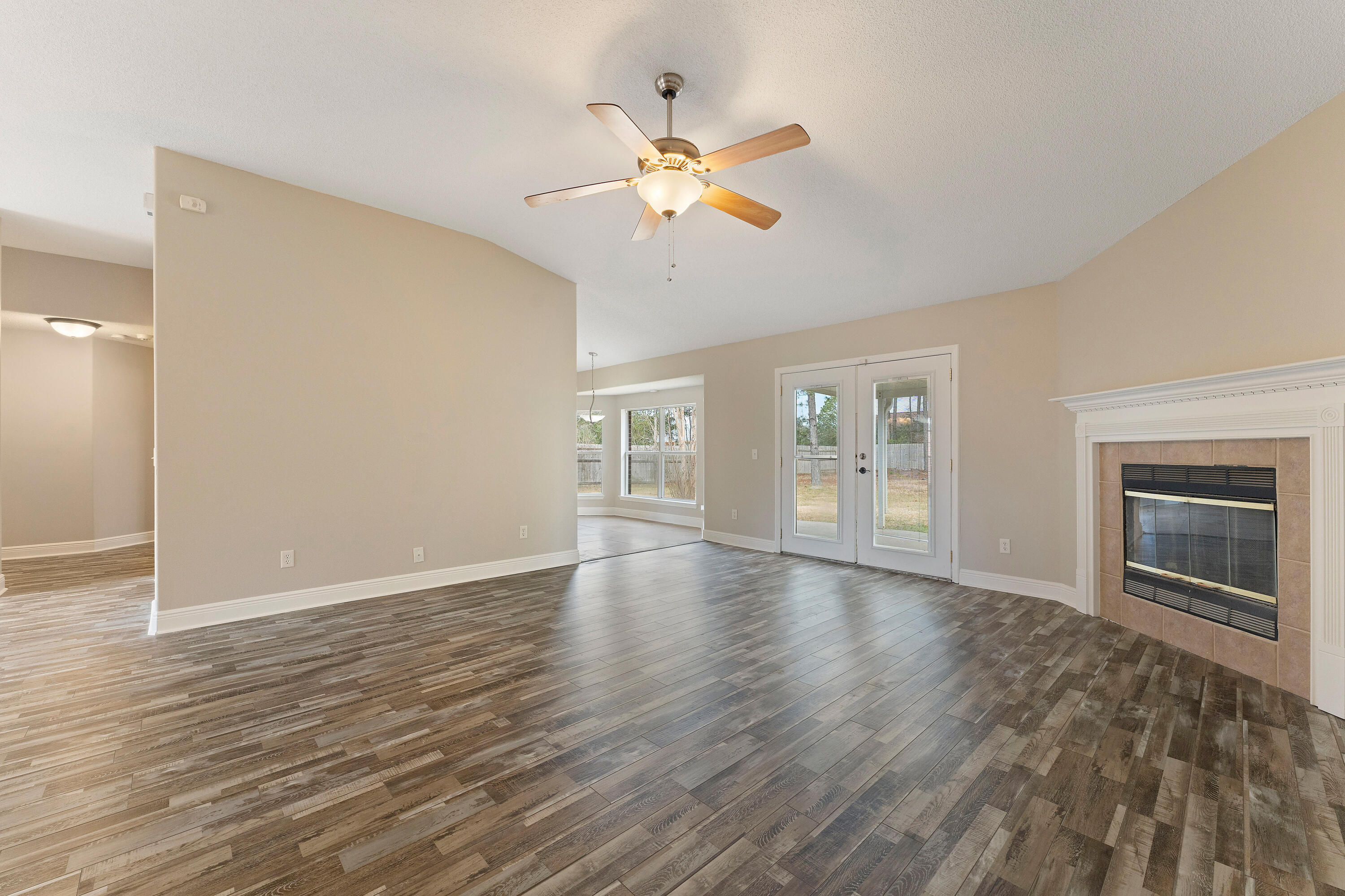 7162 Riverview Road Navarre, FL 32566 - Photo 9 of 33 a view of an empty room with wooden floor and a window
