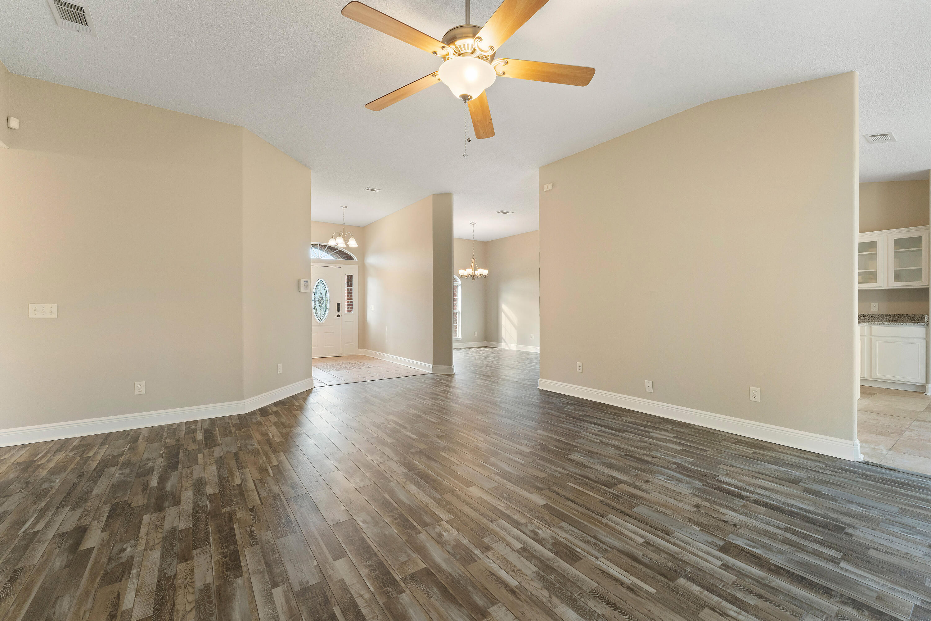 7162 Riverview Road Navarre, FL 32566 - Photo 10 of 33 wooden floor in an empty room with a window