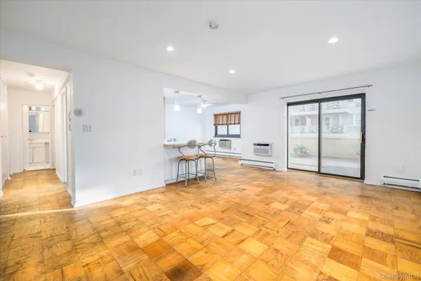 a view of an empty room with kitchen and a window