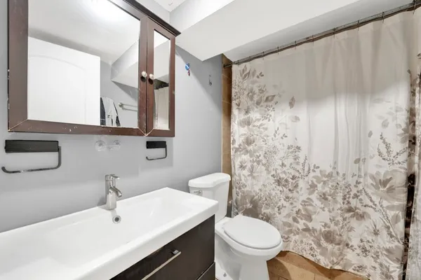 a bathroom with a sink a toilet and shower curtain