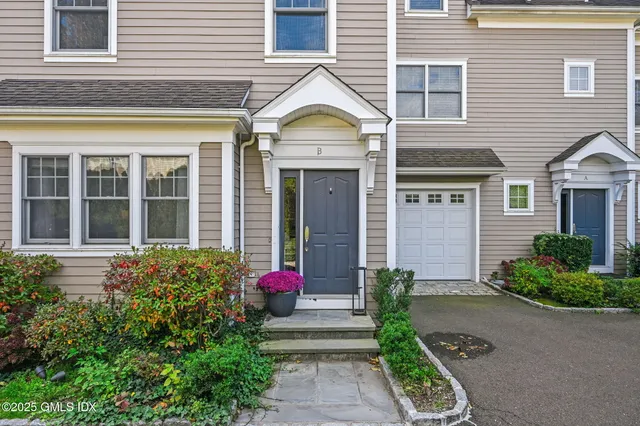 a front view of a house with a yard and potted plants