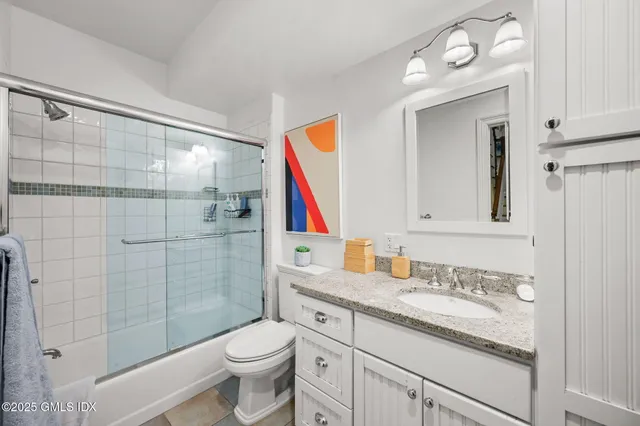 a bathroom with a sink vanity mirror and toilet