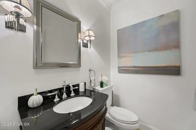 a bathroom with a granite countertop sink mirror and toilet