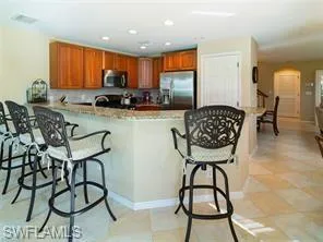 a kitchen with stainless steel appliances granite countertop a table and chairs in it
