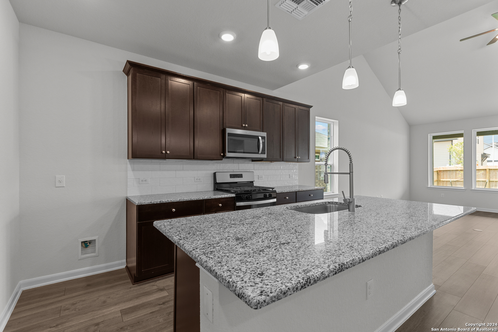 10515 Briceway Bay Helotes, TX 78254 - Photo 3 of 15 a kitchen with granite countertop stainless steel appliances a sink and a counter space