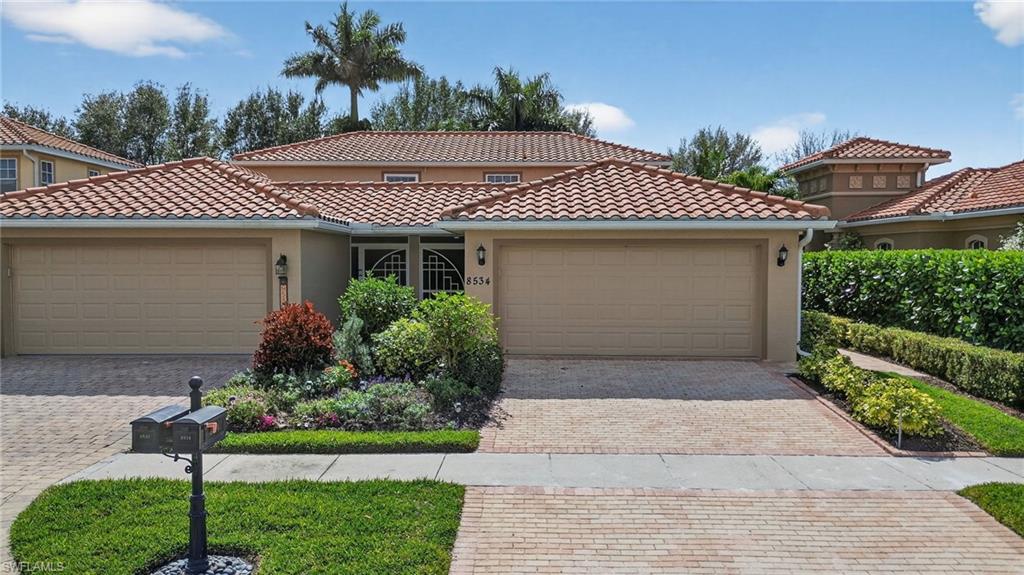 8534 Chase Preserve Drive Naples, FL 34113 - Photo 1 of 44 Mediterranean / spanish-style house with a garage, stucco siding, a tile roof, and driveway